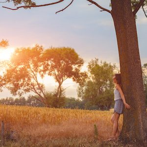 Girl leaning against an oak tree for strength and solace.