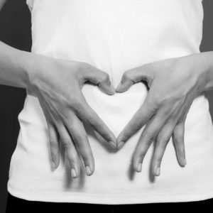 Woman's hands on stomach heart