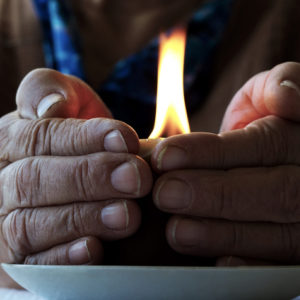 Devotional hands around a candle