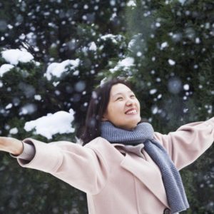 Happy woman with arms outstretched in snow