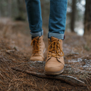 Woman hiking along near tree roots