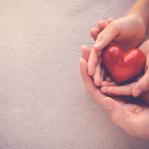 Adult and child hands holding heart