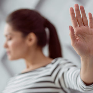 A woman holds her hand in a stop motion