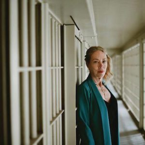 Dr. Karen Gedney standing in front of prison bars