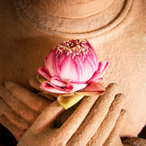 Sandstone Buddha with lotus blossom in hands