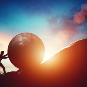 True Grit: Man pushing huge concrete ball up hill