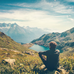 Man sitting on a mountain top looking at the view