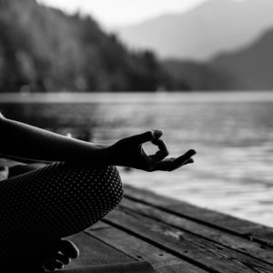 Woman meditating by lake