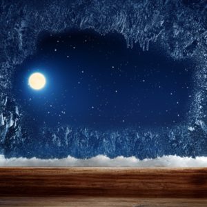 Moon outside of an icy winter window