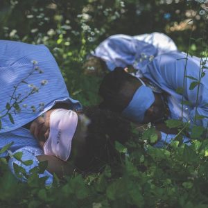 two women in sleep masks laying in the foliage