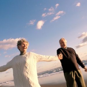 Older couple holding hands on beach