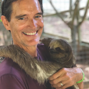 Paul Sutherland holding a sloth