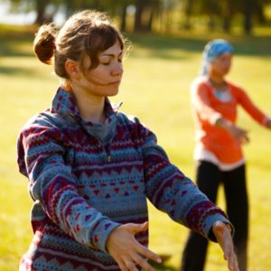 Two women practicing qi gong in nature