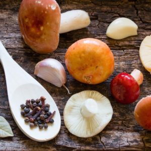 Raw mushrooms and spices on wood surface