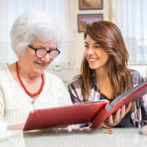 Grandmother and granddaughter looking through photo album