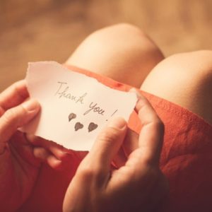 Woman holding gratitude note