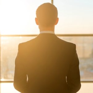 Man in suit looking out window