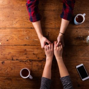 Couple holding hands on wood table