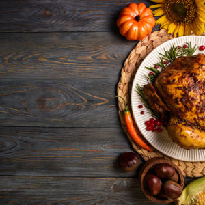 Roast turkey with autumn vegetables for thanksgiving dinner on wooden background