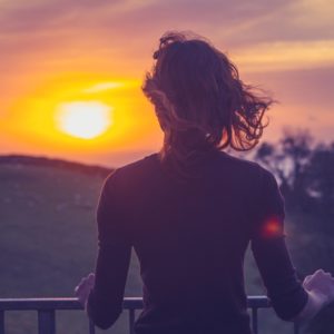 Woman at sunset looking toward sky