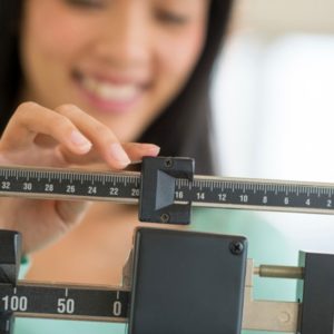 Woman weighing herself on scale