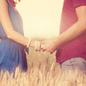 Couple holding hands in field