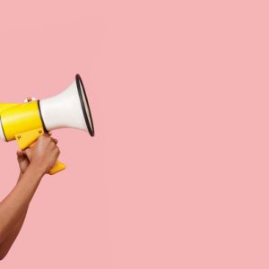 A young woman is using affirmations for speaking your truth, expressed with a photo of a bullhorn.