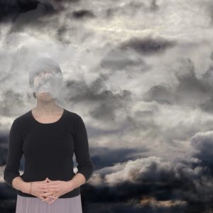 Sad woman with her head in dark clouds.