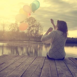 Woman with balloons on dock