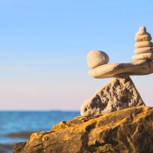 Zen stones balancing on ocean cliff