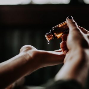 woman adds drop of essential oil for yoga practice