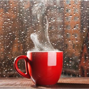 steaming coffee in rain covered window