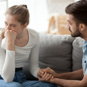 Caring husband holds wife hand while making peace after an argument