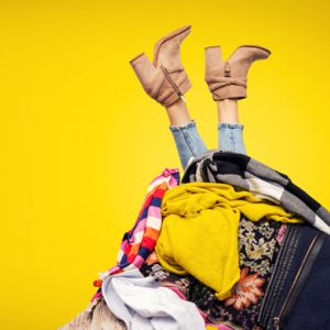 woman's legs sticking out of pile of clothes