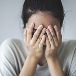 woman with head in hands distressed nervous system