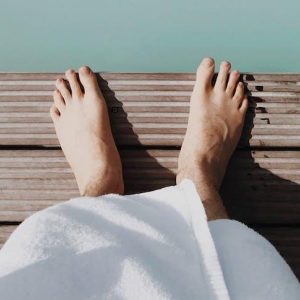 bare foot in robe by blue water