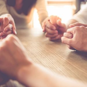 Grieving women holding hands