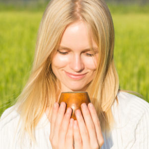 Happy woman drinking herbal tea for digestive health in late summer, Earth element