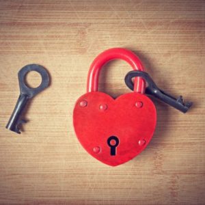 Image of heart lock and key on wood