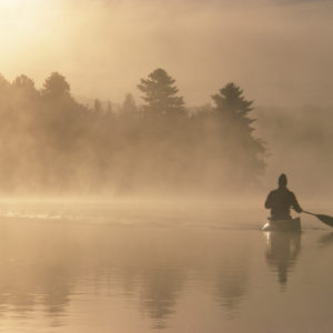 kayaking through fog and light on a lake