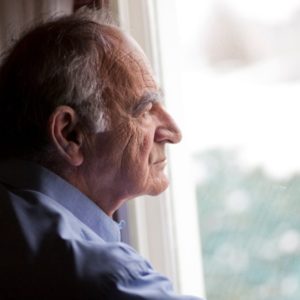 Older man looking out window