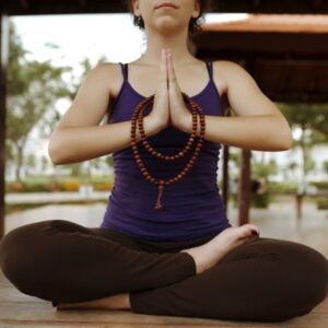 Woman meditating with strand of mala beads