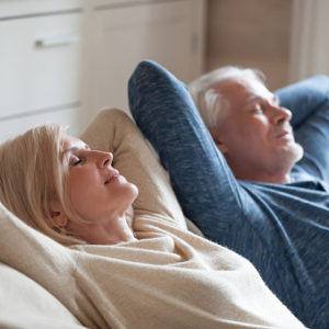 Calm mature couple relaxing on sofa together peacefully.