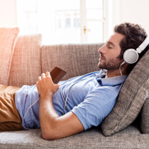 Man lying on couch listening to music