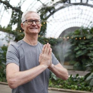 man holding palms together saying namaste