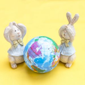 wooden rabbit toys looking at a wooden earth in shock for easter for animal lovers