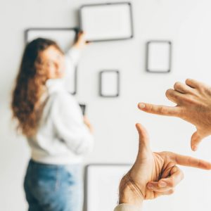 woman adjusting picture frame on wall Post-Traumatic Thriving Dr. Randall Bell