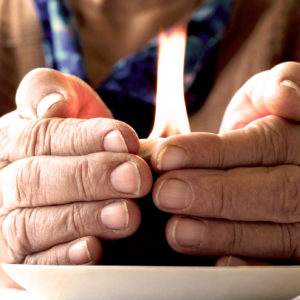 Woman with hands by candle