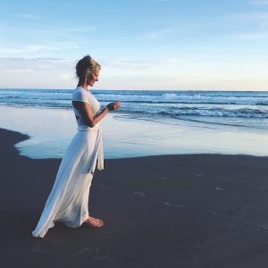 Shiva Rea on beach in white dress