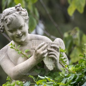 Statue of the pagan god pan surrounded by foliage